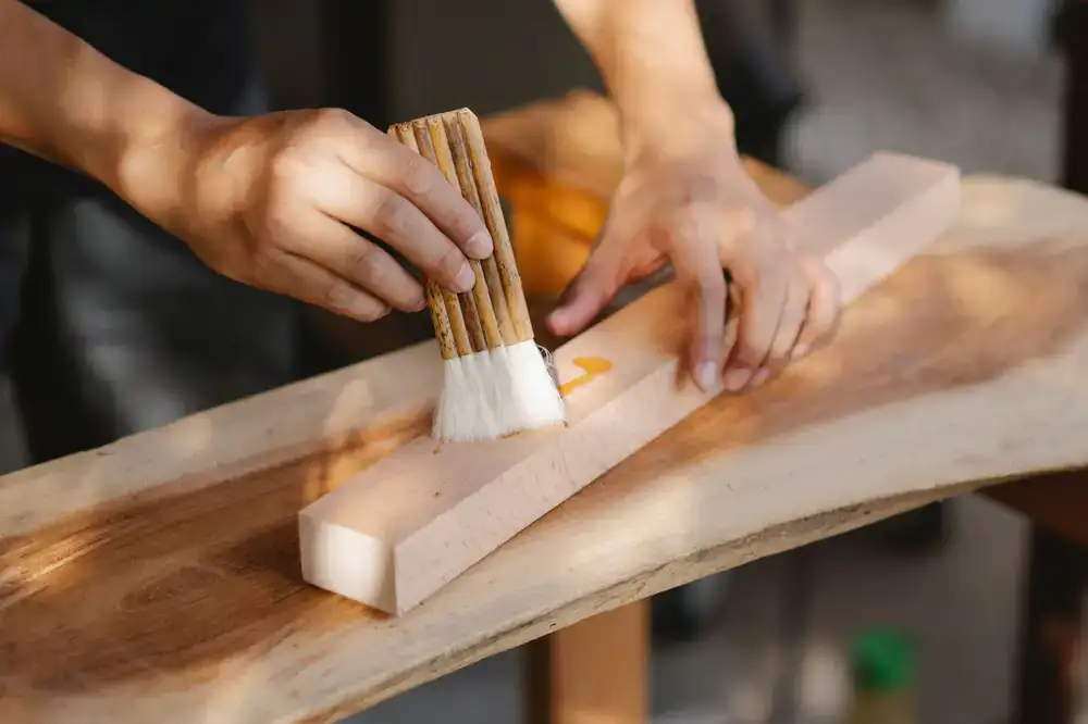 Artisan applying finish to a wooden chair